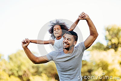 Portrait of young father carrying his daughter on his back Stock Photo