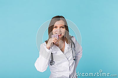 Young female doctor tasting pack of pills Stock Photo