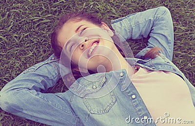 Portrait of young female while lying in spring green garden Stock Photo