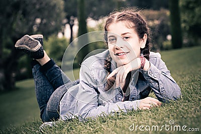 Portrait of young female while lying in spring green garden Stock Photo