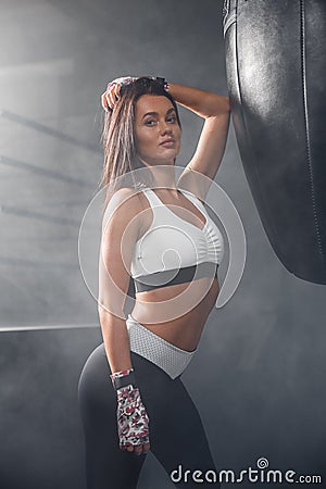 Portrait of young fitness woman flexing muscles and smiling Stock Photo