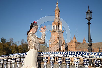 Portrait of young flamenco woman, Hispanic and brunette, with typical flamenco dance suit, with bullfighter jacket, playing palms Stock Photo