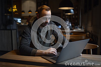 Portrait of young freelancer, man who using laptop in cafe Stock Photo