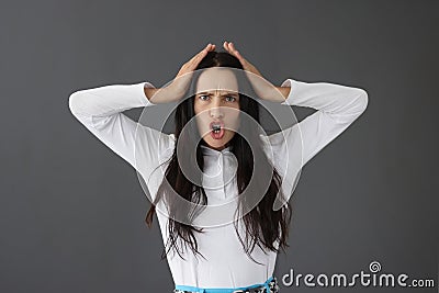 Portrait of young frowning displeased woman on gray background Stock Photo