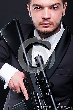 Portrait of young gangster holding armed rifle Stock Photo