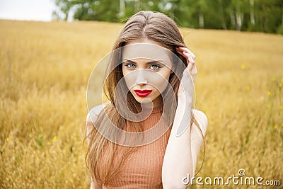 Portrait of a young girl on a background of golden wheat field Stock Photo