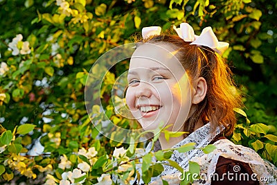 Portrait of a young girl in an old school uniform of the USSR with a black dress and a white apron. Teenager in the Park among the Stock Photo