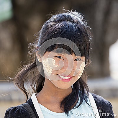 Portrait young girl with thanaka on her smile face is happiness. Myanmar, Burma Editorial Stock Photo