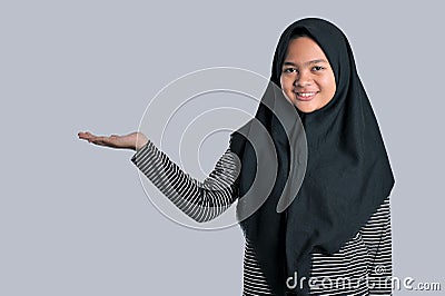 Portrait of a young girl wearing islamic headscarf showing blank area for sign or copyspase Stock Photo