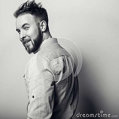 Portrait of young handsome friendly man in bright shirt. Black-white studio photo on light grey background Stock Photo