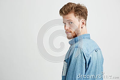 Portrait of young handsome man smiling looking turning to camera over white background. Stock Photo