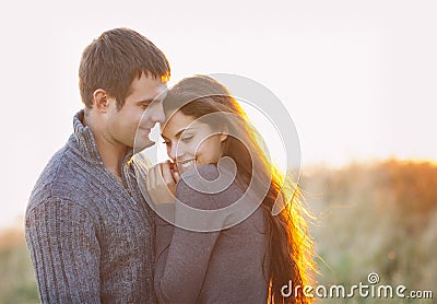 Portrait of young happy couple laughing in a cold day by the autumn sea Stock Photo