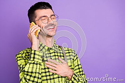 Portrait of young happy positive laughing man talking on phone hear funny news isolated on purple color background Stock Photo