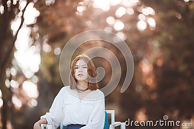Portrait of young hipster Asian girl posing in the autume park forest bokeh background Stock Photo