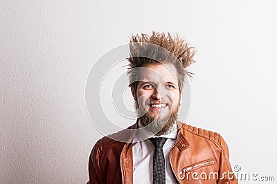 Portrait of a young hipster man with messy hairstyle in a studio. Copy space. Stock Photo