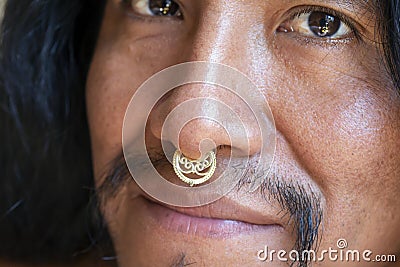 Man with long hair wearing a metal septum piercing at his nose Stock Photo