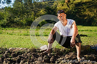 Portrait of a young indian farmer resting in the fields captured early in the morning Stock Photo