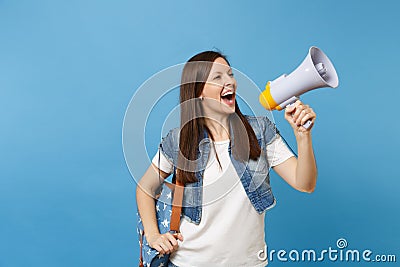 Portrait of young laughing beautiful woman student in denim clothes with backpack make announcement with megaphone Stock Photo