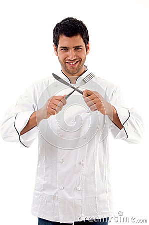 Portrait of young male chef holding fork and knife Stock Photo