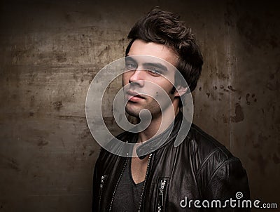 Portrait of a young man against the background of a metal wall with free space Stock Photo