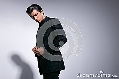 Portrait of a young man in checkers suit, posing confident businessmen, looking down, standing isolated on white. Stock Photo