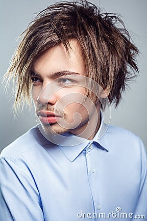 Portrait of young man with fringe messy hairstyle. studio shot Stock Photo