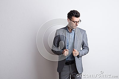 Portrait of a young man with glasses in a studio, dressed in gray suit. Stock Photo