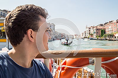 Portrait of a young man on a Grand Canal cruise on the bow of a river tram. The look is directed to the horizon. Stock Photo