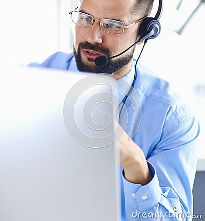 Portrait of a young man with a headset in front of a laptop computer Stock Photo