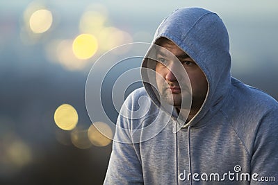 Portrait of young man in hooded sweatshirt / jumper on blurred b Stock Photo