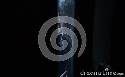 Portrait of young man in image of black magician with magic wand Stock Photo