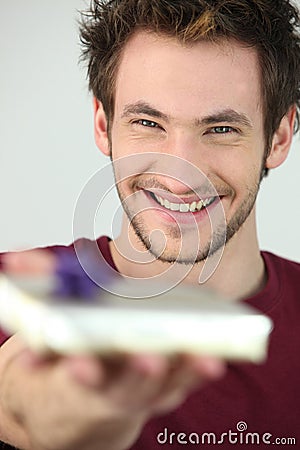 Portrait of a young man offering gift Stock Photo