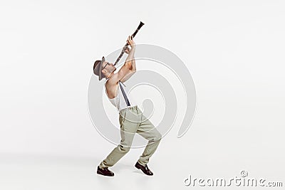 Portrait of young man playing clarinet isolated over white studio background. Stylish model Stock Photo