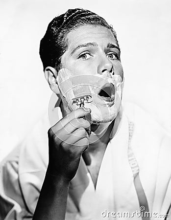 Portrait of a young man shaving Stock Photo