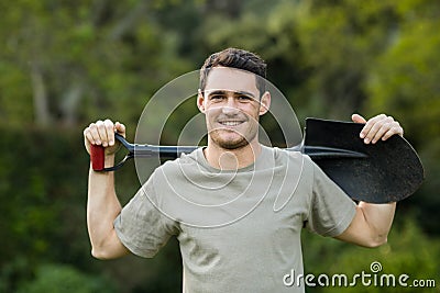 Portrait of young man standing with a gardening shovel Stock Photo