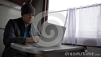 Portrait young man on the train, prints on laptop Stock Photo