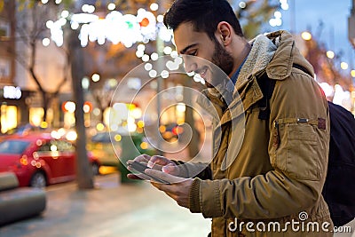 Portrait of young man using his mobile phone on the street at ni Stock Photo