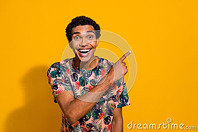 Portrait of young man wear t shirt exotic print direct finger mockup amazed repost content in tiktok isolated on yellow Stock Photo