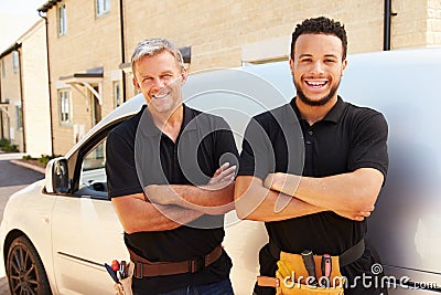 Portrait of a young and a middle aged tradesman by their van Stock Photo