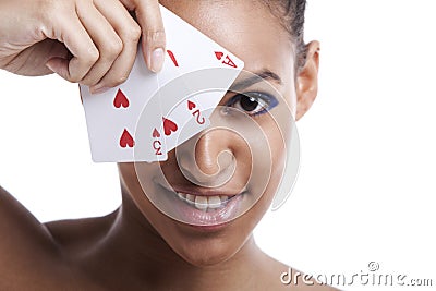 Portrait of young Mixed Race woman with playing cards biting her lip against white background Stock Photo