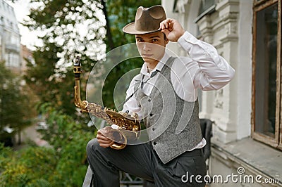 Portrait of young musician holding saxophone musical instrument Stock Photo