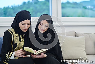 Portrait of young muslim women reading Quran in modern home. Stock Photo