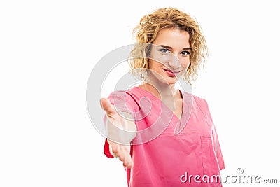 Portrait of young nurse wearing pink scrub offering hand shake Stock Photo