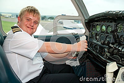 Portrait of young pilot with down syndrome in cabin. Stock Photo