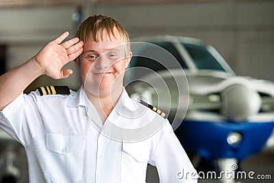 Portrait of young pilot with down syndrome in hangar. Stock Photo