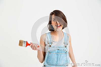 Portrait of young playful crazy beautiful girl, holding paint brush Stock Photo