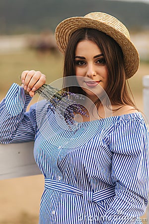 Portrait of young pregnant woman near the farm. Close up view of lady in hat with lavender in hand. Smile Stock Photo