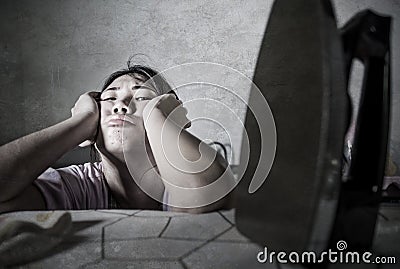 Portrait of young pretty frustrated and stressed Asian Korean woman looking sad at iron working at home kitchen ironing clothes ti Stock Photo