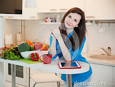 Portrait of young pretty woman in the kitchen. Stock Photo