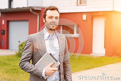 Portrait of a young real estate agent in front of a house Stock Photo